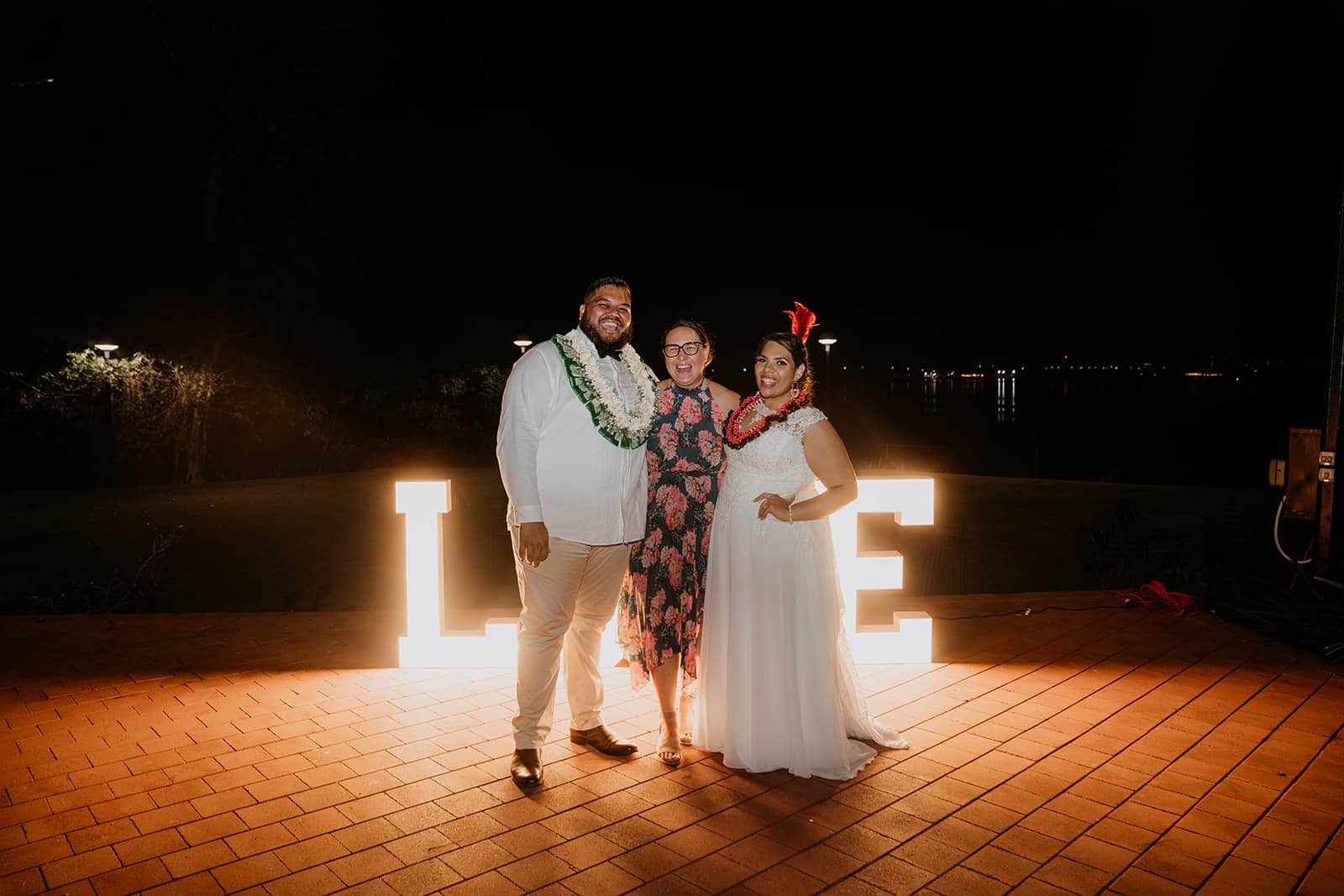 Wedding planner and couple standing in front of LED letters